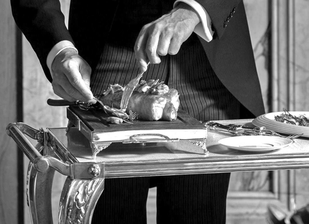 A maître d' carefully placing silverware on linen